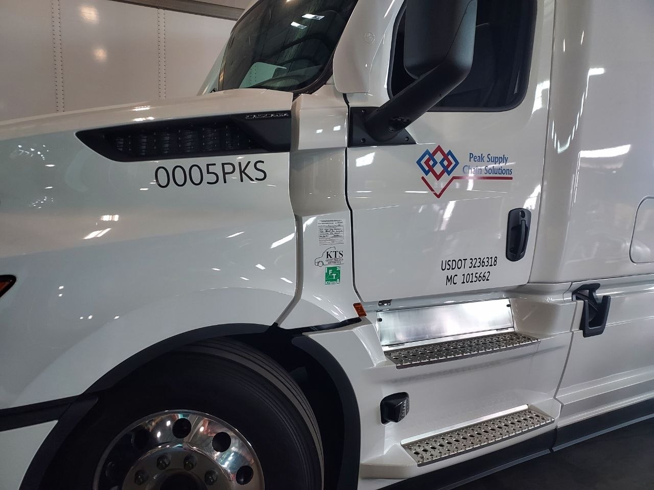 Peak unit 0005PKS, a white Freightliner Cascadia sleeper, photographed from the front quarter with the Peak mark and USDOT number on the door